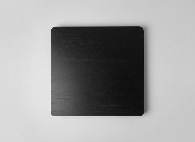 Black metal sheet on a textured gray surface