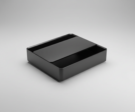 Black rectangular box on a concrete floor with a cardboard background